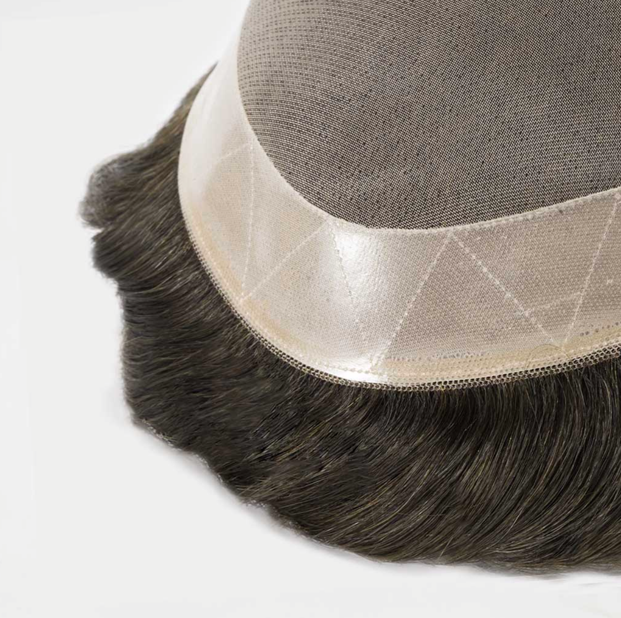 Close-up of a hairpiece with a mesh backing on a white background